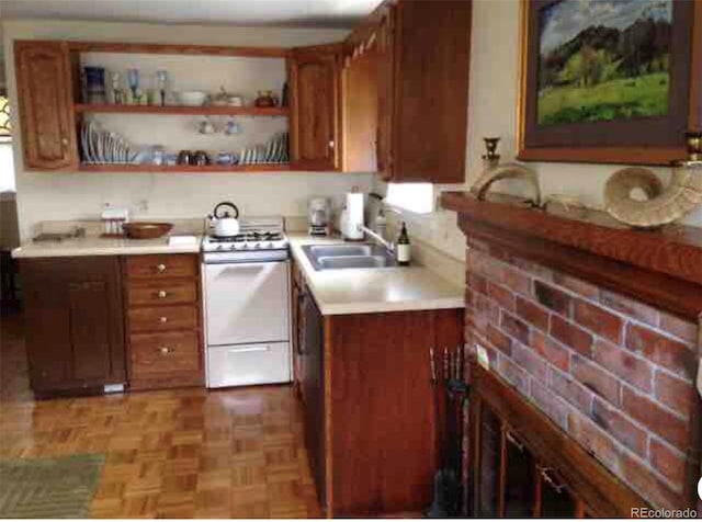 kitchen with sink, white stove, and light parquet flooring