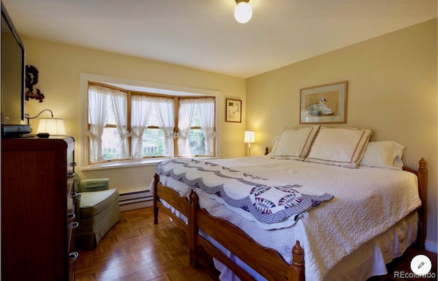 bedroom with dark parquet floors and baseboard heating