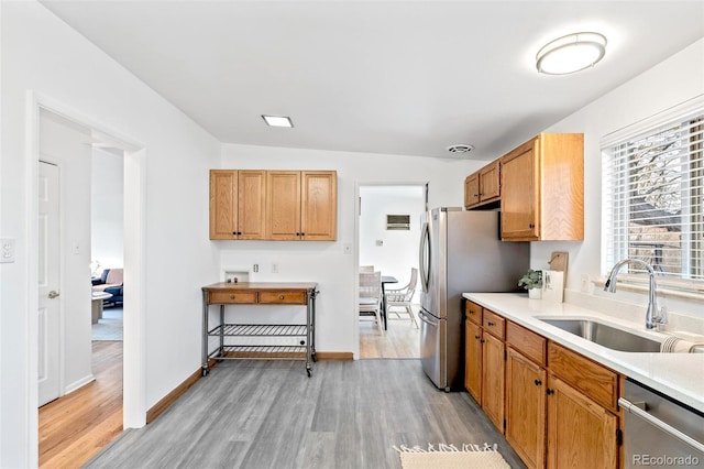 kitchen featuring sink, stainless steel appliances, lofted ceiling, and light wood-type flooring