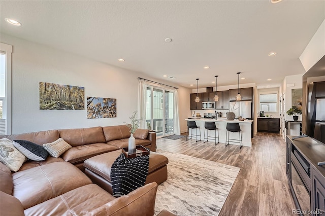 living area featuring recessed lighting and light wood-style flooring