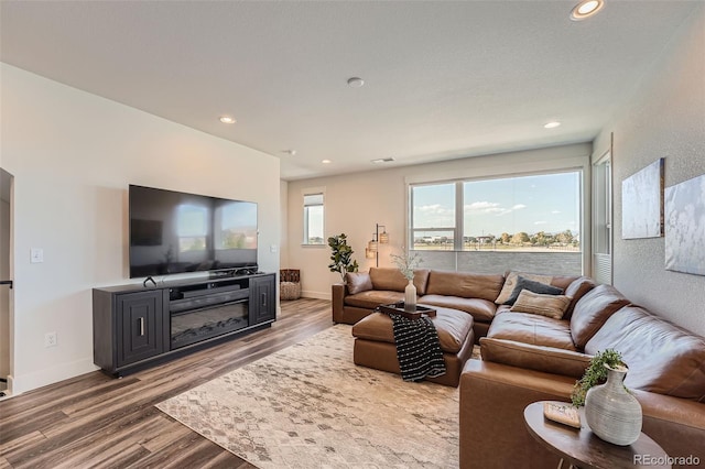 living area featuring recessed lighting, baseboards, and wood finished floors