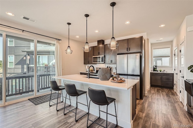 kitchen with visible vents, appliances with stainless steel finishes, wood finished floors, and light countertops