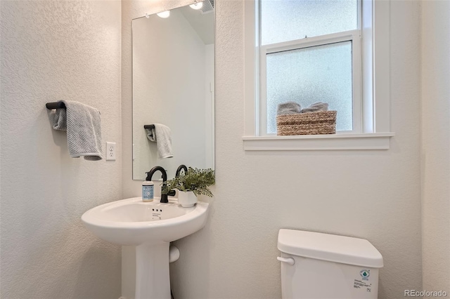 half bathroom featuring visible vents and toilet