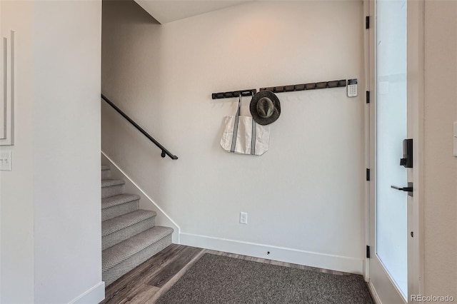 staircase featuring baseboards and wood finished floors