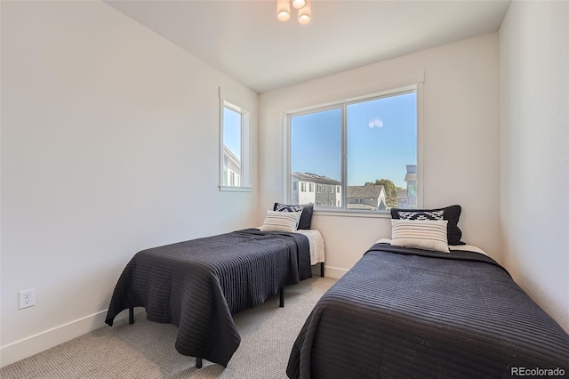 bedroom with light colored carpet and baseboards