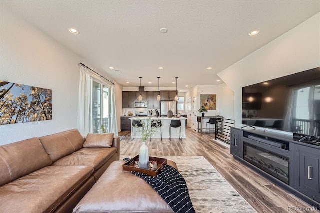 living area with light wood finished floors and recessed lighting