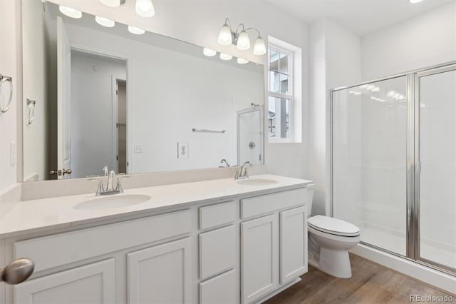 bathroom with vanity, wood-type flooring, toilet, and a shower with shower door