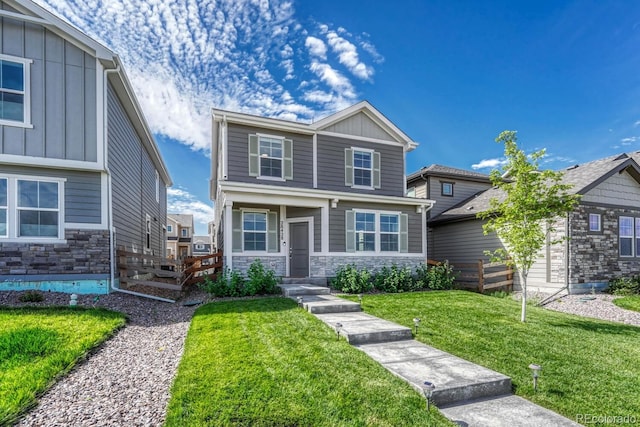 craftsman house featuring board and batten siding, stone siding, and a front lawn