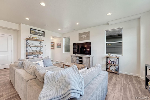 living area with baseboards, light wood-style flooring, and recessed lighting