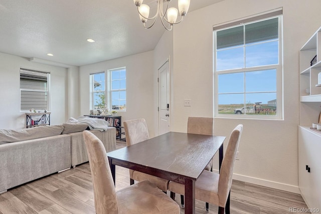 dining space with baseboards, light wood finished floors, recessed lighting, and a notable chandelier