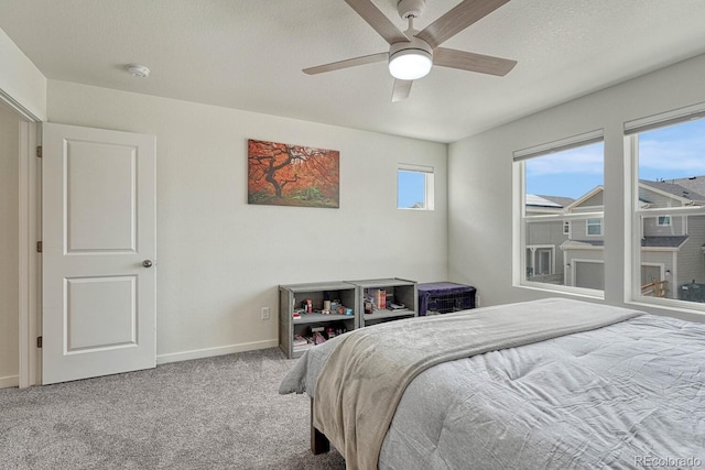 bedroom featuring a textured ceiling, carpet flooring, a ceiling fan, and baseboards