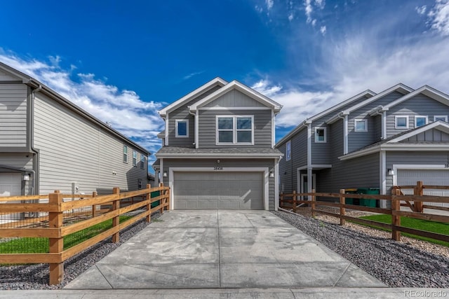 view of front of property featuring a fenced front yard, concrete driveway, and a garage