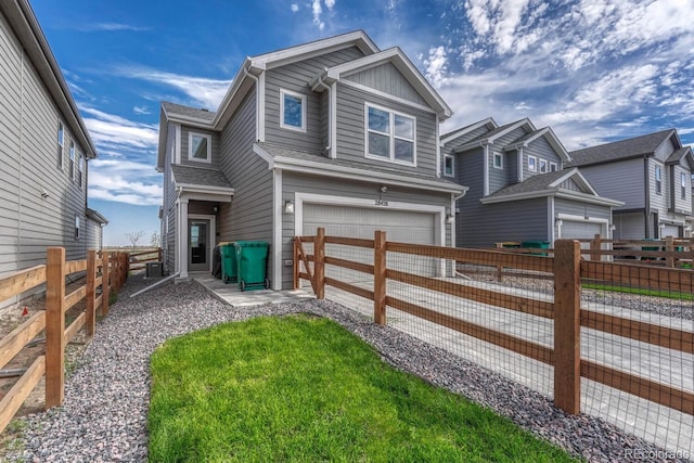 view of front of home with a garage, a residential view, fence, and concrete driveway