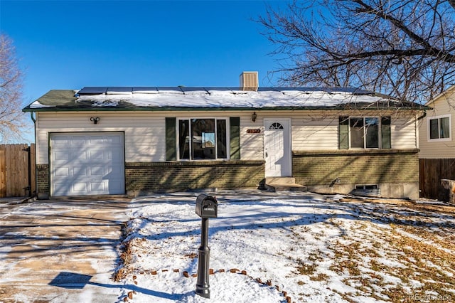 ranch-style home with solar panels and a garage