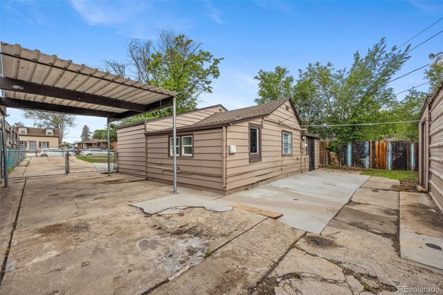 530 S Quitman St, Denver, CO 80219 - view of side of home with driveway, a fenced backyard, a carport, and a patio area