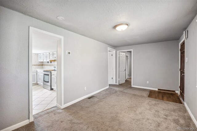 530 S Quitman St, Denver, CO 80219 - unfurnished bedroom featuring light carpet, a textured ceiling, ensuite bathroom, and baseboards