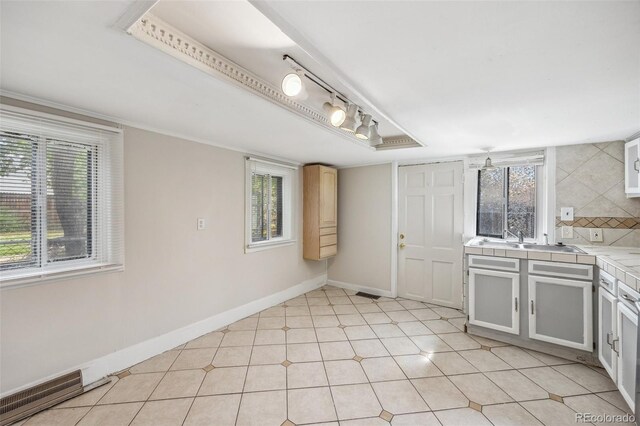 530 S Quitman St, Denver, CO 80219 - kitchen featuring tile countertops, plenty of natural light, a sink, and baseboards