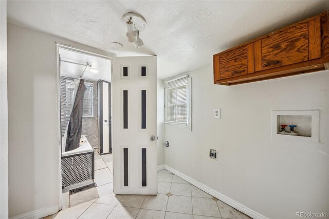 530 S Quitman St, Denver, CO 80219 - laundry room with washer hookup, light tile patterned floors, baseboards, hookup for an electric dryer, and a textured ceiling