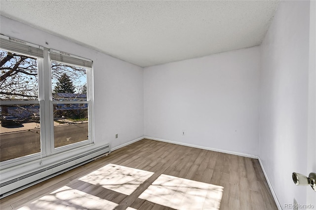 1796 S Yampa Way, Aurora, CO 80017 - empty room with a baseboard heating unit, wood finished floors, a textured ceiling, and baseboards