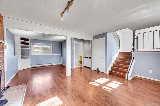 1796 S Yampa Way, Aurora, CO 80017 - unfurnished living room featuring baseboard heating, wood finished floors, a fireplace, stairway, and a textured ceiling
