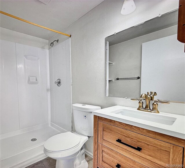 1796 S Yampa Way, Aurora, CO 80017 - full bathroom with a stall shower, toilet, tile patterned floors, and vanity