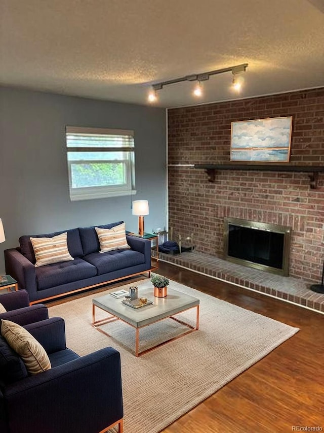 1796 S Yampa Way, Aurora, CO 80017 - living room featuring track lighting, wood finished floors, a textured ceiling, and a fireplace