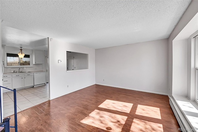 1796 S Yampa Way, Aurora, CO 80017 - spare room featuring baseboard heating, a textured ceiling, light wood-style floors, and a sink