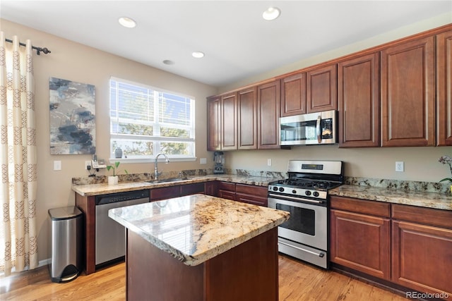9290 Melborne Ct, Parker, CO 80134 - kitchen with appliances with stainless steel finishes, a sink, light stone counters, recessed lighting, and light wood-style flooring
