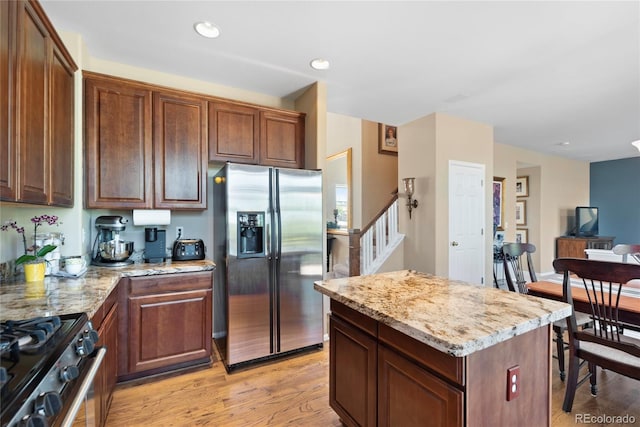 9290 Melborne Ct, Parker, CO 80134 - kitchen featuring stainless steel appliances, light stone countertops, light wood-type flooring, a center island, and recessed lighting