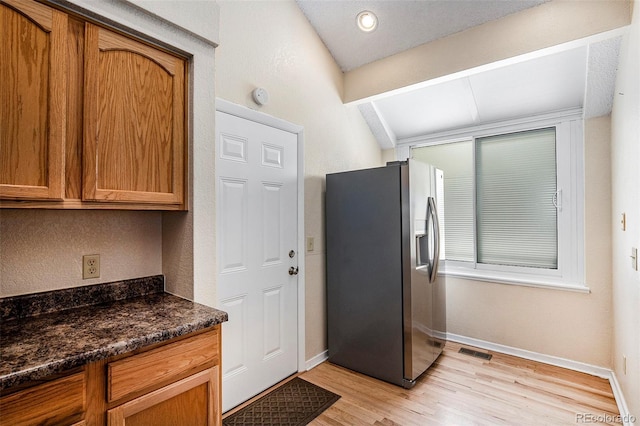 4493 Dunkirk Way, Denver, CO 80249 - kitchen featuring stainless steel refrigerator with ice dispenser, light wood-style flooring, baseboards, and brown cabinetry