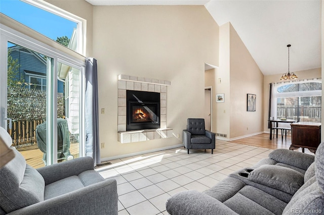 4493 Dunkirk Way, Denver, CO 80249 - living area featuring high vaulted ceiling, a chandelier, a tile fireplace, tile patterned flooring, and baseboards