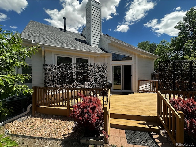 4493 Dunkirk Way, Denver, CO 80249 - back of property featuring central AC, a deck, a chimney, and a shingled roof