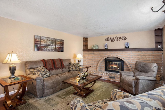 living room featuring a brick fireplace and a textured ceiling