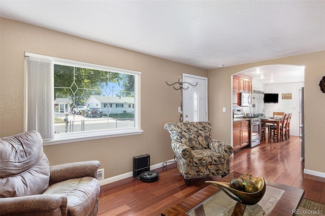 living room with dark hardwood / wood-style floors and a textured ceiling