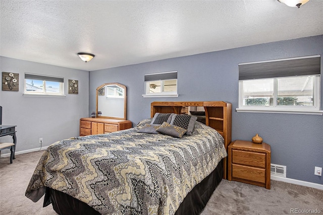 bedroom with light carpet and a textured ceiling