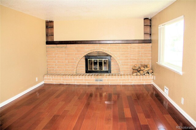 7891 Poplar St, Commerce City, CO 80022 - unfurnished living room featuring wood finished floors and a fireplace