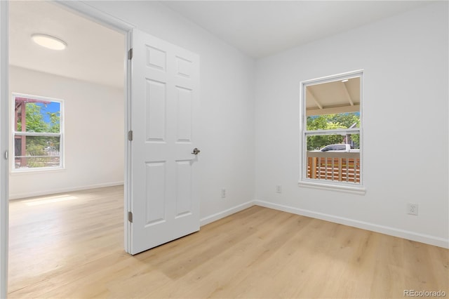 unfurnished room with light wood-type flooring and plenty of natural light