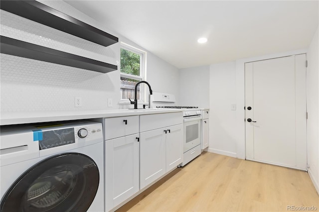 laundry room with light wood-type flooring, sink, and washer / dryer