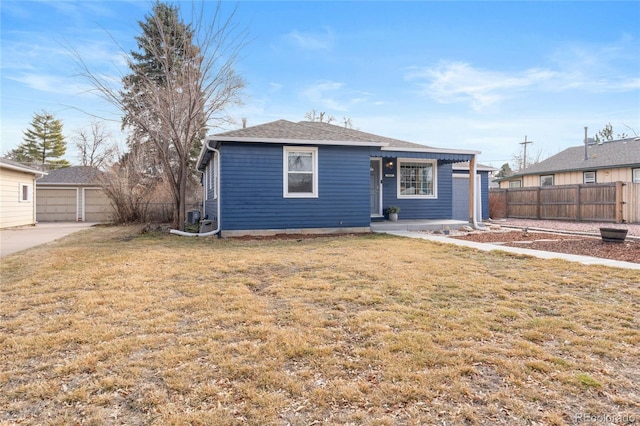 view of front facade featuring a front lawn, a detached garage, and fence