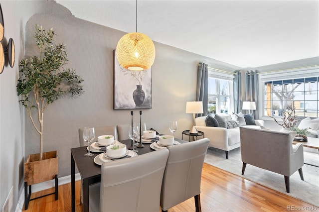 dining area with light wood-style flooring and baseboards