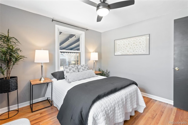 bedroom with a ceiling fan, baseboards, and wood finished floors