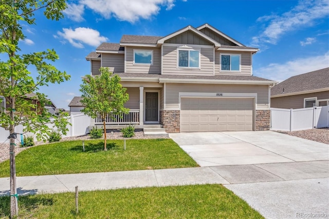 craftsman-style home with concrete driveway, an attached garage, board and batten siding, a front yard, and fence