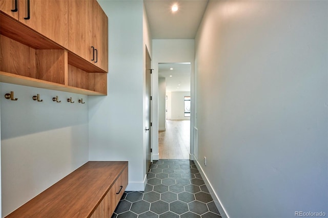 mudroom with dark tile patterned floors