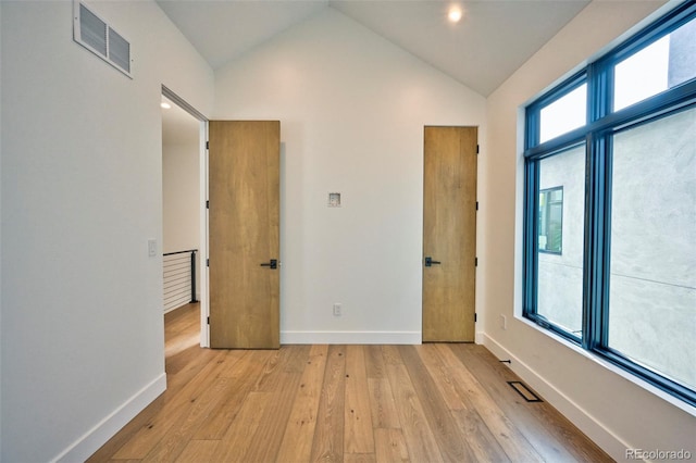 empty room featuring lofted ceiling and light wood-type flooring