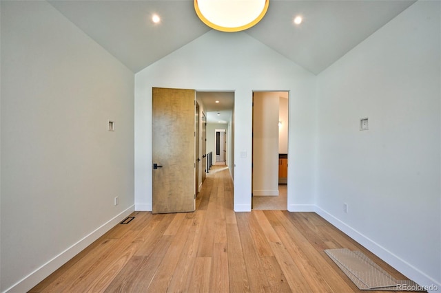 empty room featuring vaulted ceiling and light hardwood / wood-style flooring