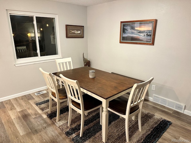 dining area with a textured ceiling and hardwood / wood-style flooring