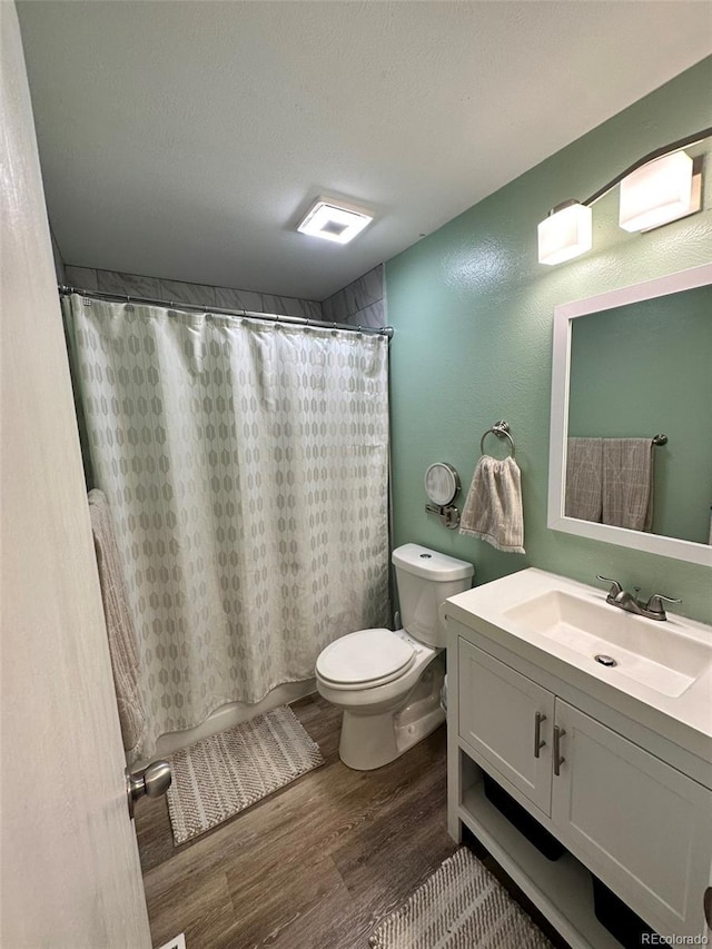 bathroom featuring hardwood / wood-style floors, vanity, a textured ceiling, and toilet