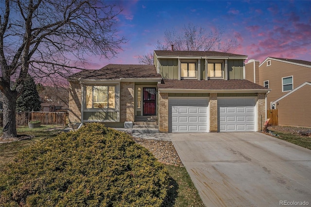 split level home with fence, board and batten siding, concrete driveway, a garage, and brick siding