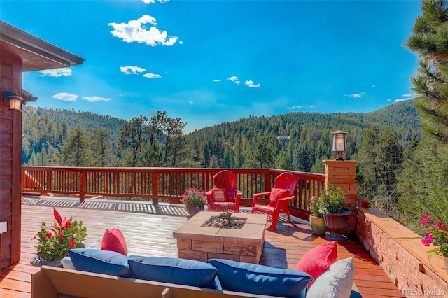 deck with a mountain view and an outdoor living space with a fire pit