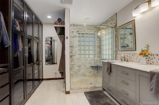 bathroom featuring vanity and a shower with door